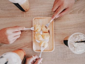 Midsection of woman holding ice cream on table