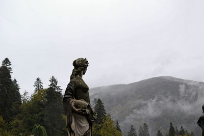 Statue on mountain against sky