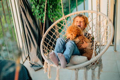 Portrait of little girl, dog in hammock