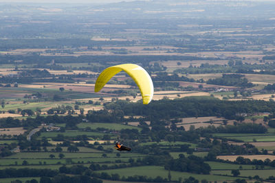 Hot air balloon flying over landscape against cityscape