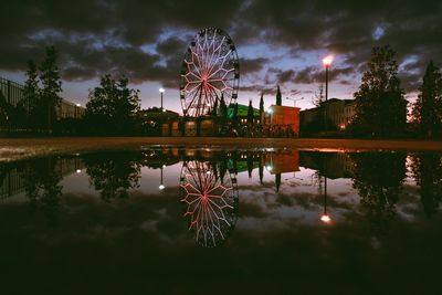 Fireworks over lake against sky at night