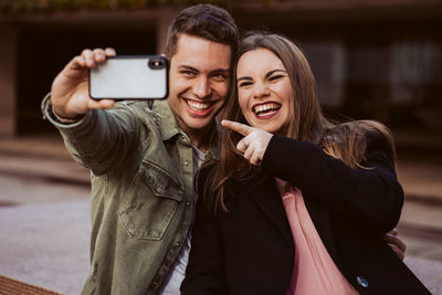 Portrait of smiling young woman using mobile phone