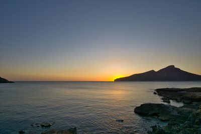 Scenic view of sea against clear sky during sunset