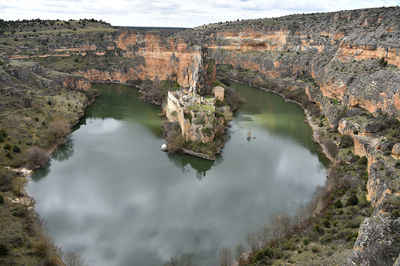 High angle view of lake amidst rock formation against sky