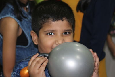 Close-up of boy playing with balloons