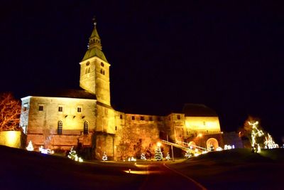 Low angle view of illuminated buildings against sky at night