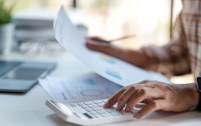 Midsection of man using laptop on table