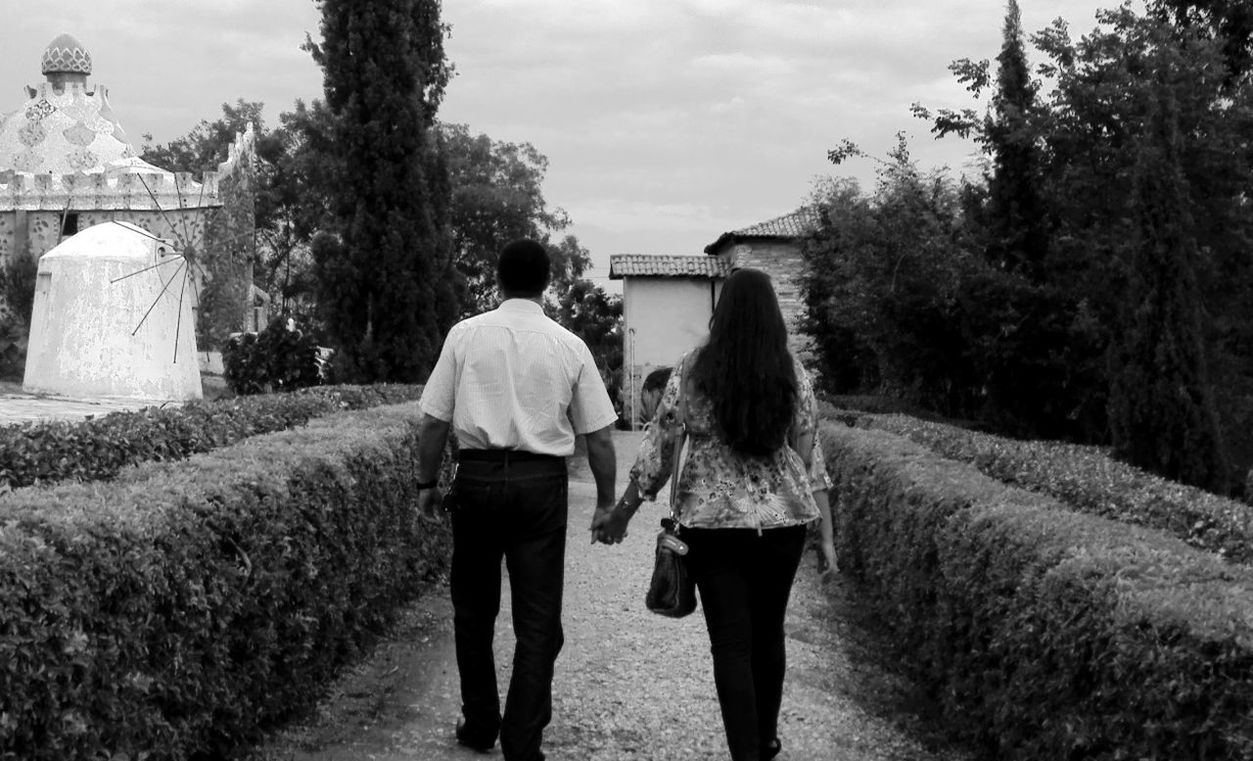 rear view, real people, two people, tree, lifestyles, walking, women, outdoors, leisure activity, day, men, friendship, togetherness, sky, architecture