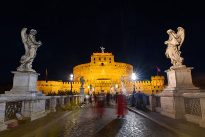 Statue of illuminated historic building at night