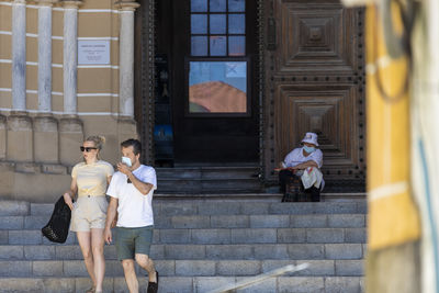 People on staircase outside building