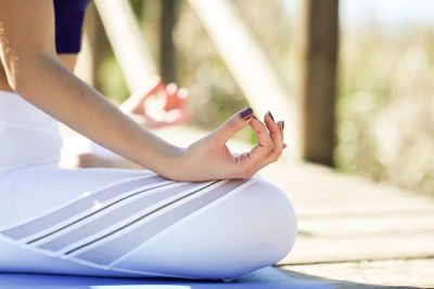 Midsection of woman sitting in lotus position