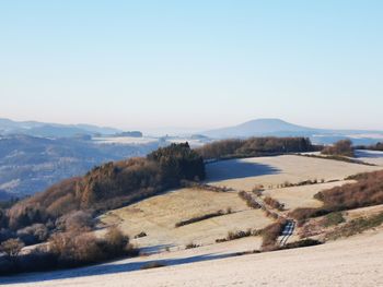 Scenic view of landscape and mountains against clear sky