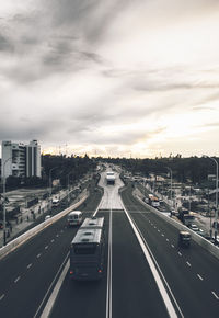 Vehicles on highway against sky in city