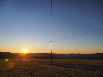 Scenic view of field against clear sky during sunset