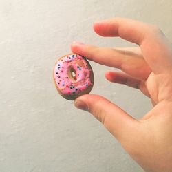 Cropped hand holding small donut