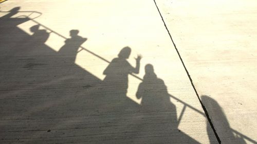 Low section of people standing by shadow