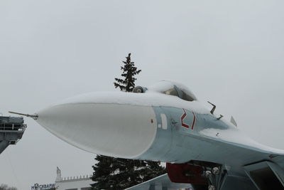 Airplane flying over snow against clear sky