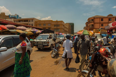 People on car against sky in city