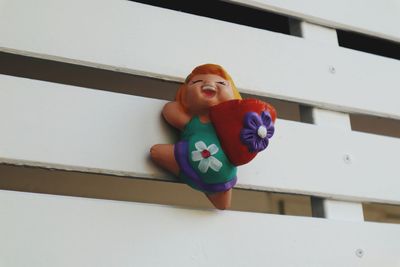 Low angle view of boy looking through toy on wall