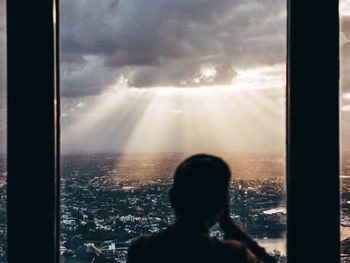 Silhouette of woman against cloudy sky