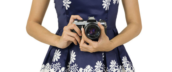 Midsection of woman holding camera against white background