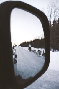 Road seen through side-view mirror of car