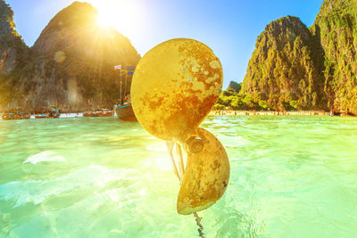 Rocks in swimming pool by sea against sky on sunny day