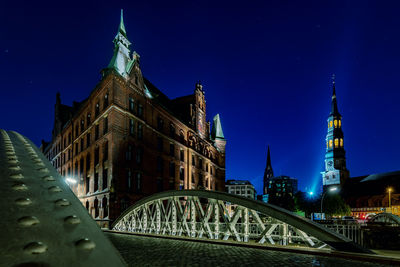 Low angle view of illuminated building against sky at night