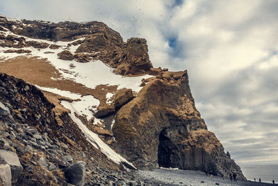 Tourists visiting cave on beach landscape photo