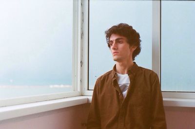 Thoughtful man standing by window