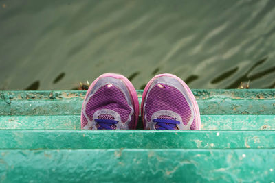 Low section of person wearing purple shoes