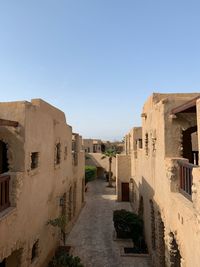 View of old buildings against clear blue sky