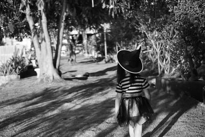 Rear view of girl wearing hat while walking in park