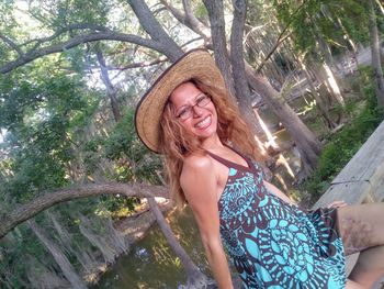 Portrait of smiling woman in hat standing outdoors