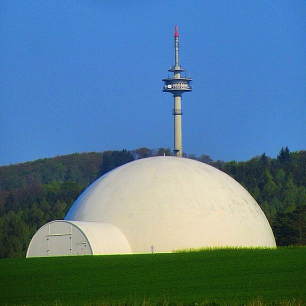 clear sky, blue, built structure, architecture, copy space, grass, lighthouse, building exterior, field, landscape, day, guidance, tree, outdoors, green color, direction, dome, religion, no people, nature