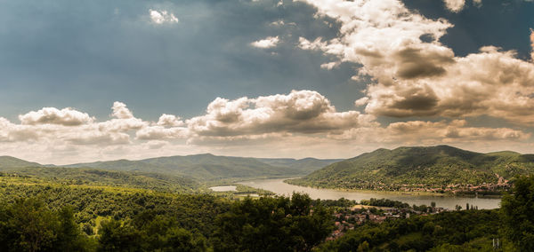 Scenic view of river and mountains against sky