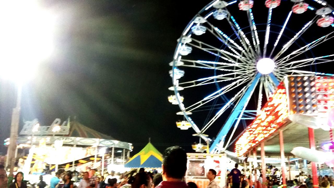 amusement park, amusement park ride, arts culture and entertainment, low angle view, large group of people, leisure activity, illuminated, enjoyment, incidental people, lifestyles, person, men, celebration, fun, ferris wheel, carousel, sky, lighting equipment, hanging