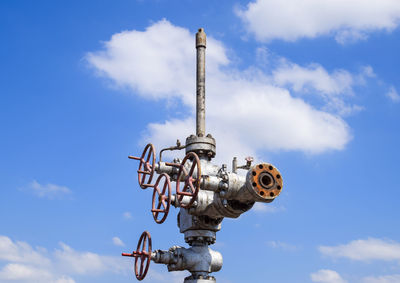 Low angle view of machinery against sky