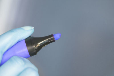 Close-up of human hand against blue background