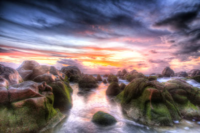 Scenic view of sea against cloudy sky during sunset