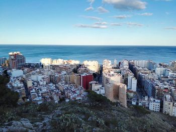 High angle view of buildings and sea against sky