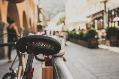 Close-up of text on bicycle seat by railing at street