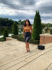 Full length of woman standing against plants