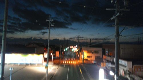 Illuminated city against sky at night