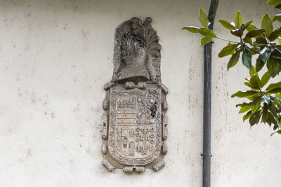 Close-up of old sculpture against wall