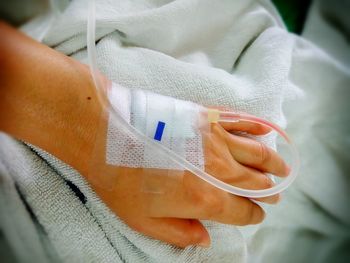 Cropped hand of patient with iv drip in hospital 