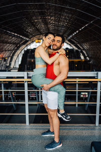 Portrait of young couple in love holding each other in gym