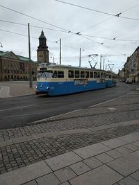 Cars on street in city against sky