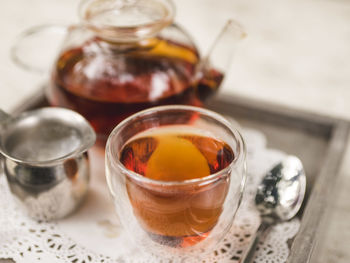 Close-up of black tea in cup by pot on table