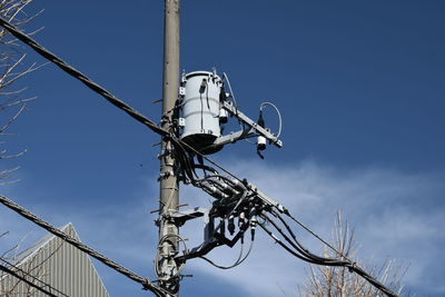 Low angle view of electricity pylon against sky